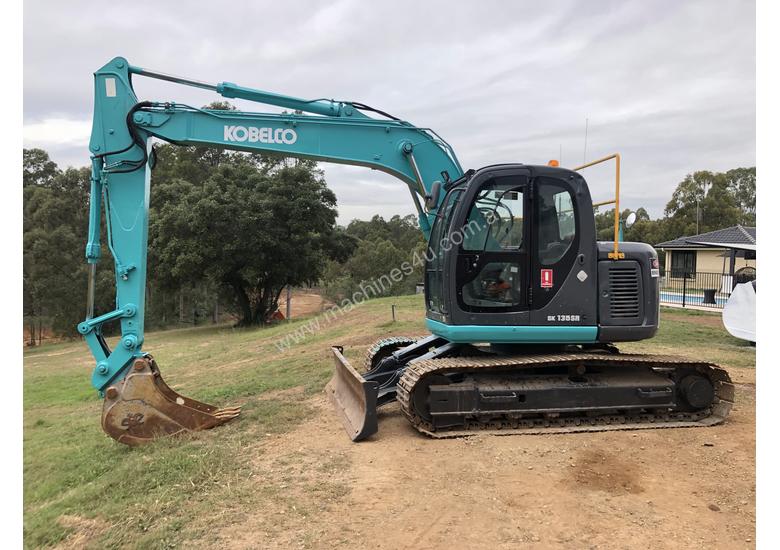 caption KOBELCO SK135SR 13.5T Excavator with Back Fill Blade